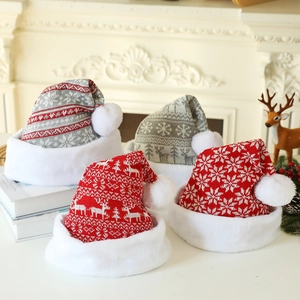 Détails de quatre bonnets de Noël en tricot avec motifs de rennes et flocons sur cheminée