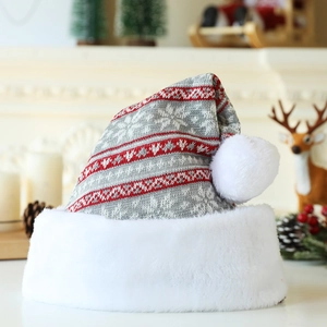 Détails de la maille d'un bonnet de Noël épais avec flocons et pompon en fausse fourrure