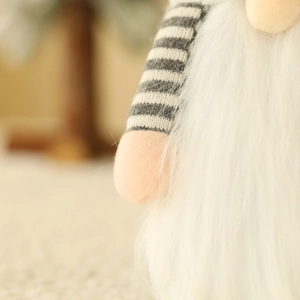 Close-up of gnome wine bottle cover with striped knit arm and soft white faux fur detail