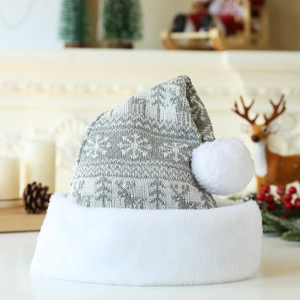 Détail du bonnet de Noël tricoté avec motifs flocons gris et pompon blanc en peluche douce
