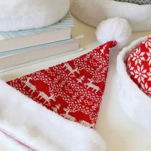 Détail du bonnet de Noël tricoté rouge avec motifs de rennes et flocons de neige blancs