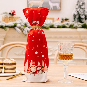 Red Christmas wine bottle covers with Santa graphics and golden ribbon on festive table