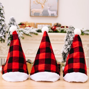 Three premium red and black buffalo plaid Christmas hats with plush trim on a festive wooden table