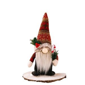 Christmas gnome plush with knitted hat and pine branch on white background
