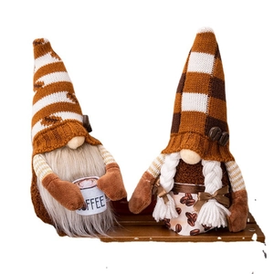 Pair of coffee-themed gnomes with knitted hats and coffee cups on wooden display