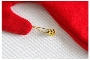 Detailed macro view of festive red felt fabric with a shiny gold bell and metallic thread