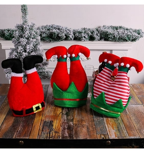 Whimsical Christmas elf leg hats featuring Santa and striped designs on wooden table