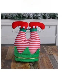 Detail of red and white striped Christmas elf leg hat with green trim and pom-poms