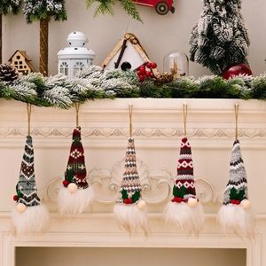 Set of five glowing knitted Christmas gnomes hanging on a cozy holiday mantle