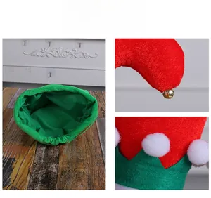 Close-up of Christmas elf hat featuring red and green felt with gold bells and plush pom-poms