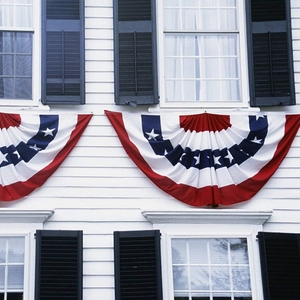 Détail du drapeau américain en éventail suspendu sur la façade d'une maison blanche