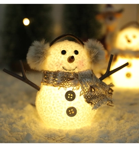 Dettaglio del pupazzo di neve luminoso con trama in maglia e luce LED calda all'interno