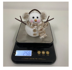 Misurazione dettagliata del peso di un simpatico pupazzo di neve in peluche per Natale