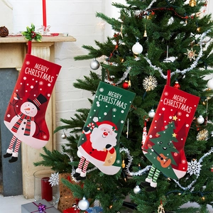 Detailed view of plush Christmas stockings with striped hanging legs on a festive tree
