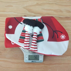 Detailed view of lightweight red Christmas chair cover on scale weighing 50.3 grams