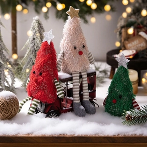 Mignonnes poupées sapin de Noël en peluche rouge, rose et vert sur fond de neige