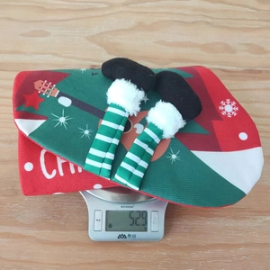 Detail view of a 52.9g Christmas stocking gift bag with striped elf legs on a digital scale