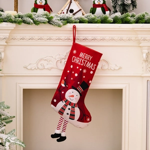 Red Christmas stocking with snowman print and striped legs hanging on a cozy fireplace