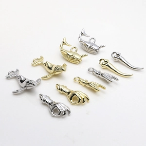 Detailed view of gold and silver plated metal charms in whale and gesture shapes