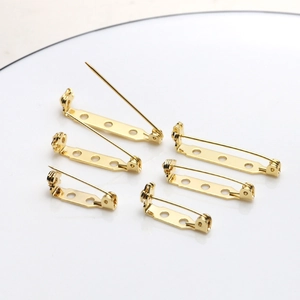 Vista macro di basi per spille placcate oro 18k per creazione di gioielli fai-da-te e hobby