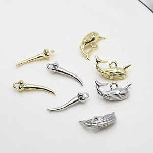 Detailed view of gold and silver plated dolphin and whale pendants for DIY jewelry