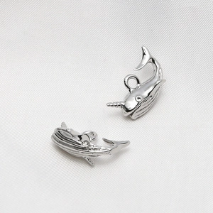 Macro shot of silver narwhal charms with polished metal finish for DIY jewelry making