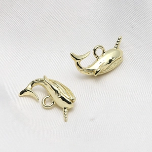 Close-up of golden narwhal charms with mirror-like finish for DIY jewelry making