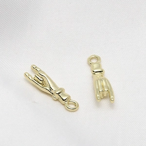 Detailed macro view of gold-plated rock hand gesture pendants for DIY jewelry making
