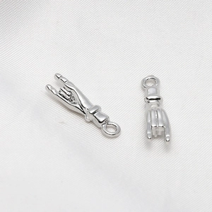 Macro view of two polished silver rock-on gesture pendants for DIY jewelry making