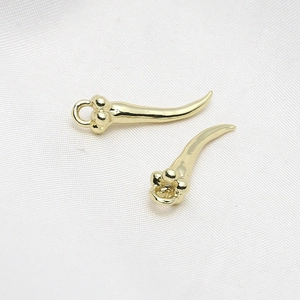 Macro shot of two polished gold-plated horn pendants for DIY jewelry making