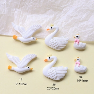Detail showing white resin swan and bird charms for DIY hair clips and phone cases