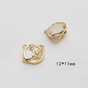 Dettaglio di ciondoli a forma di stella e pianeta placcati oro 12x11mm con madreperla