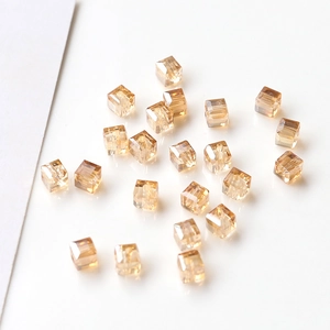 Macro shot of sparkling champagne gold square crystal beads with faceted finish and holes