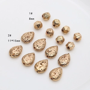 Détail de perles dorées facettées 8mm et gouttes 11x15mm avec texture lave pour bijoux