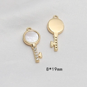 Dettaglio macro del ciondolo a chiave placcato oro 8x19mm con madreperla e zirconi