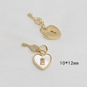 Dettaglio di ciondoli a lucchetto a cuore placcati in oro 10x12mm con madreperla e zirconi