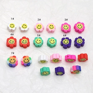 Vue macro de perles fleurs souriantes colorées pour création de bijoux DIY en tons variés