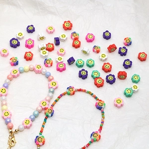 Gros plan de perles fleurs souriantes colorées en argile pour bijoux artisanaux