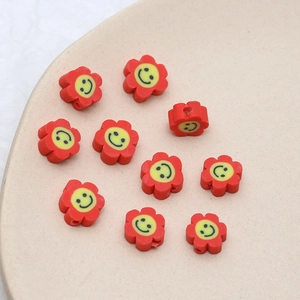 Gros plan de perles fleurs en argile colorées avec smileys jaunes pour bijoux DIY