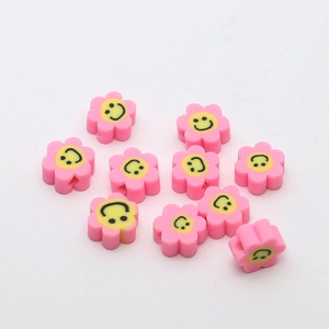 Gros plan de perles fleurs en pâte polymère colorée avec sourire pour bijoux DIY
