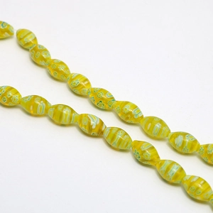 Macro detail of yellow millefiori oval glass beads with green floral patterns for DIY jewelry