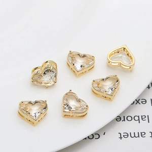 Macro view of six gold-plated heart charms with clear zircon stones for DIY jewelry