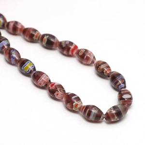 Detailed macro view of oval millefiori glass beads with colorful floral inlay patterns