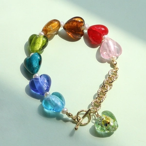 Rainbow heart glass beads bracelet with white pearls and gold OT toggle clasp on green background