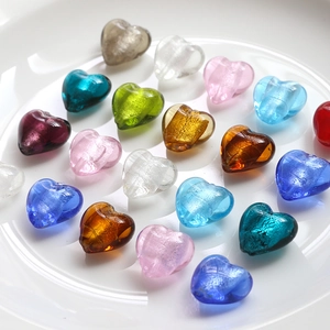 Close-up of colorful heart-shaped glass beads with glitter texture for DIY jewelry making