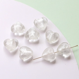 Detailed macro view of heart-shaped glass beads with glitter texture for DIY jewelry making