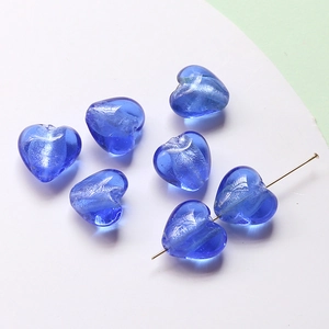 Macro detail of blue heart glass beads with shimmering foil for DIY jewelry making