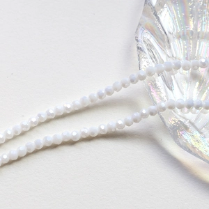 Macro shot of 4mm faceted translucent white crystal glass beads on a seashell dish
