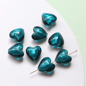 Close-up of sapphire blue heart glass beads with shimmering gold foil for DIY jewelry