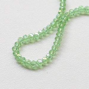Detailed macro view of 4mm faceted light green crystal rondelle beads for jewelry making
